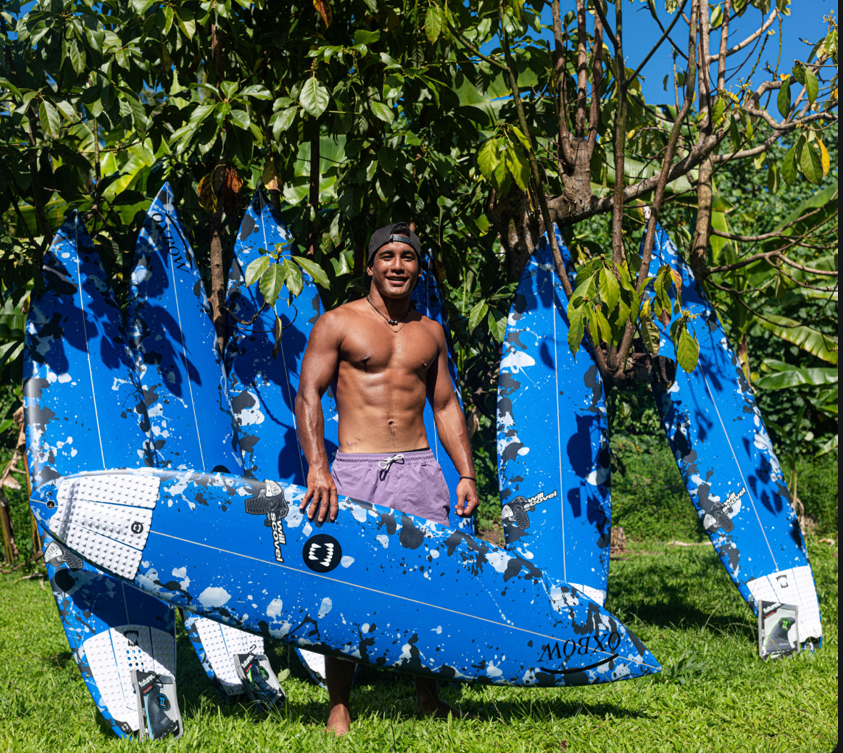 Gilbert Teave holding a blue Camo Burst Step-up Pistol, with more boards behind him